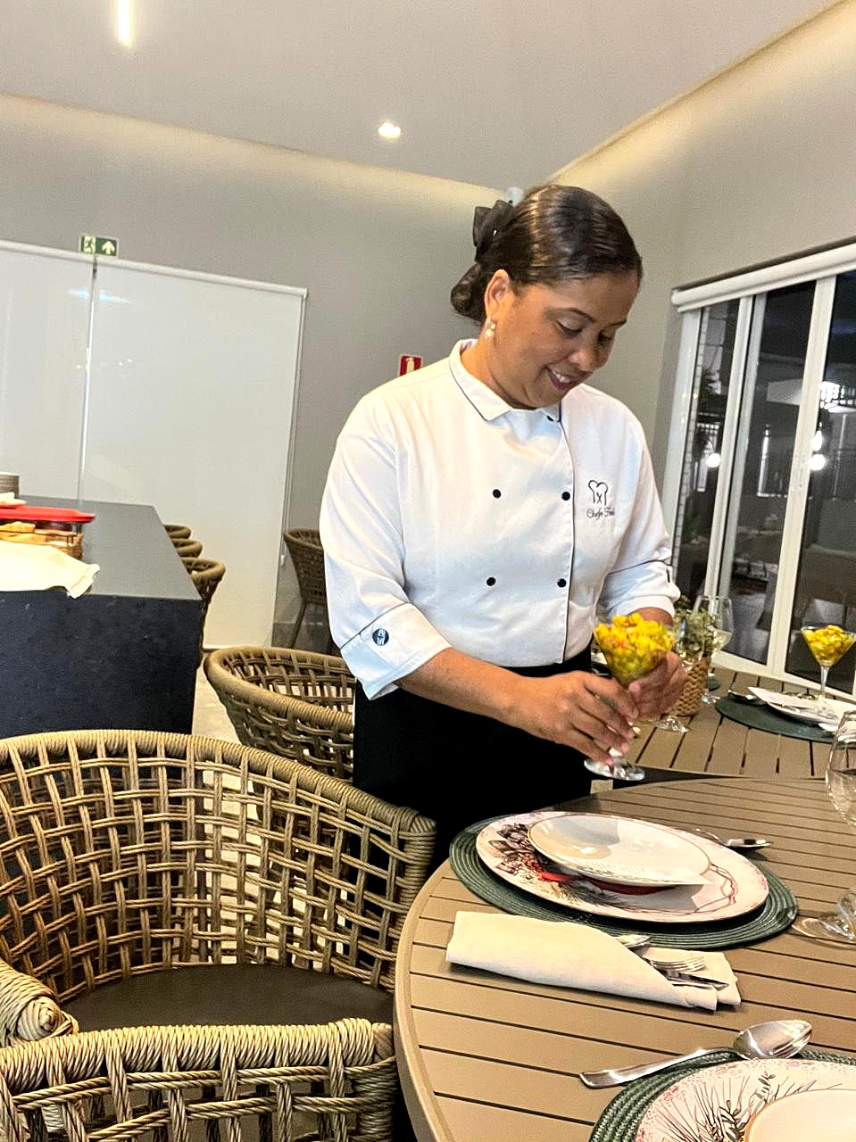 Chef Helô organizando a mesa para um atendimento de Personal Chef em viagem