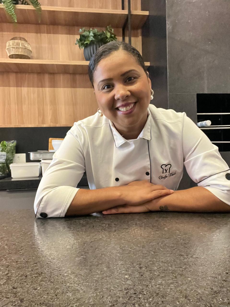 Chef Heloise Ferreira sorrindo em sua cozinha