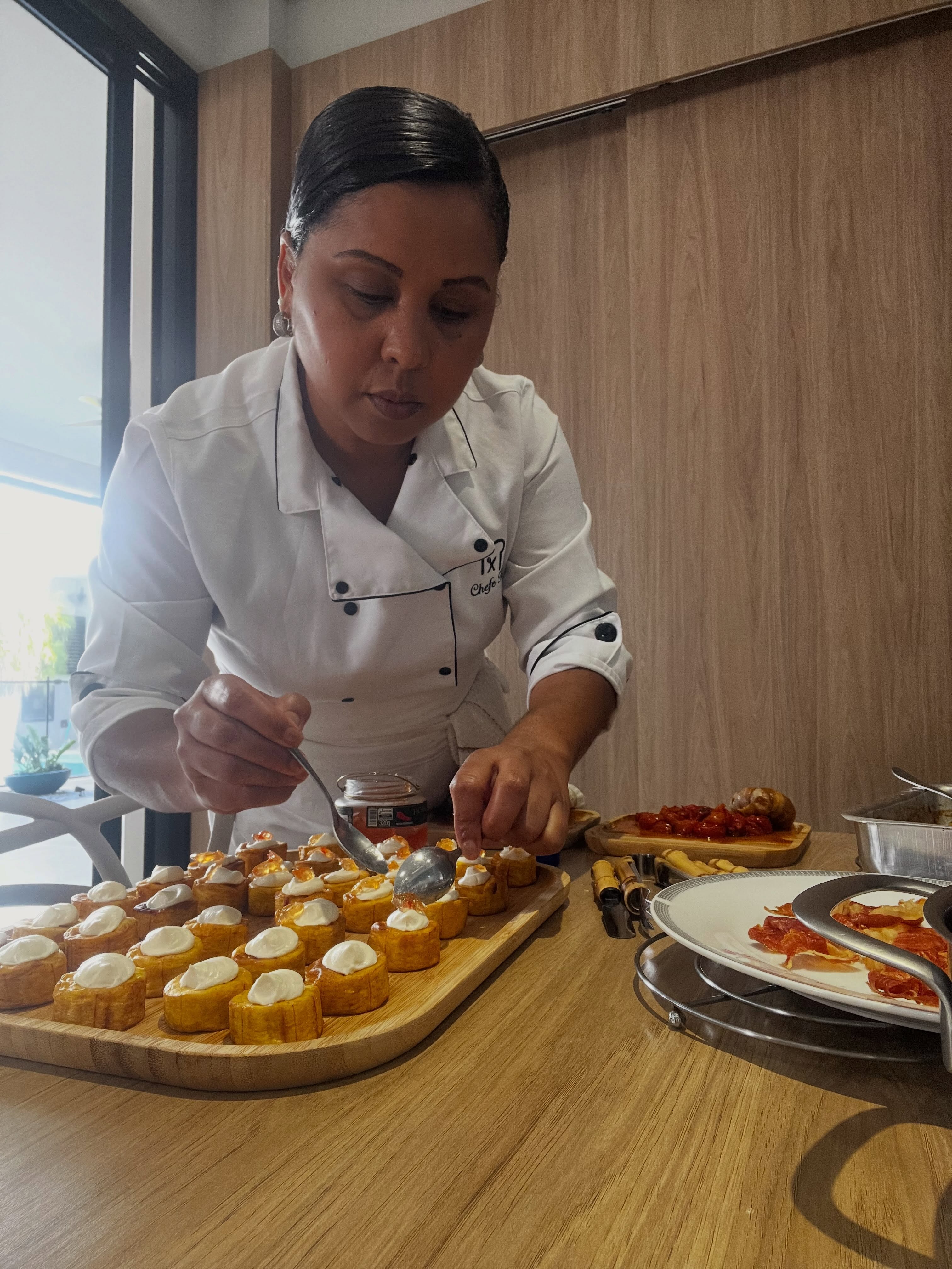 Chef Heloise Ferreira finalizando canapés durante um atendimento